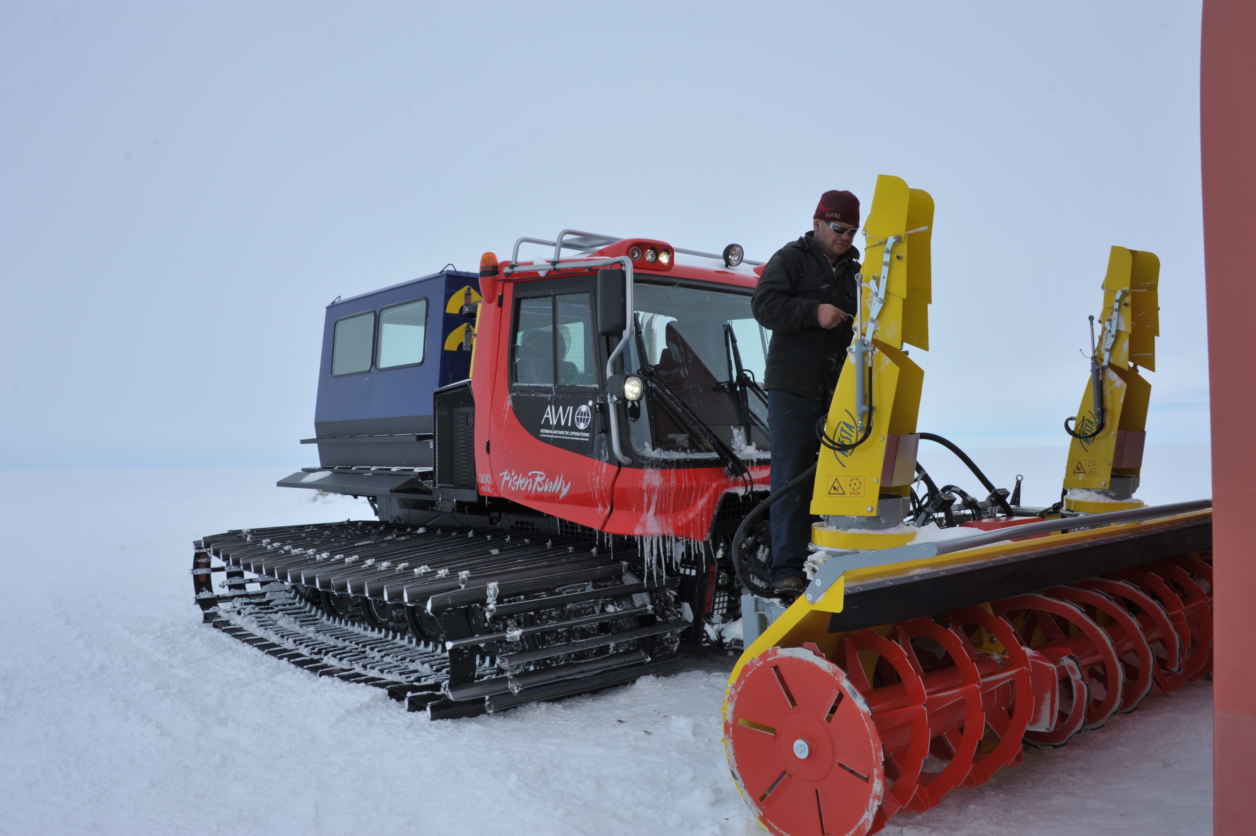 Chris monterer en snerydder på en  pistenbully traktor.