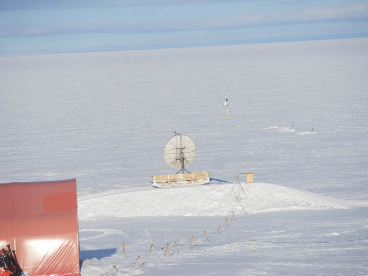 Parabolen til kommunikation står på en bakke og peger mod en geostationær satelit i kredsløb om ækvator.